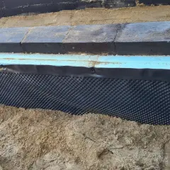 Folia kubełkowa na styropianie chroni fundament przed wilgocią.