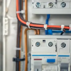W skrzynce elektrycznej widać uporządkowane **bruzdowanie pod kable**, które biegną do bezpieczników i wyłączników.