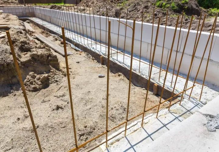 Przygotowanie zbrojenia fundamentu pod budowę. Stalowe pręty tworzą siatkę, która wzmocni beton.