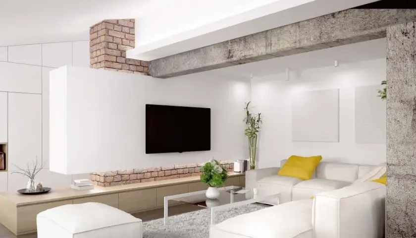 Nowoczesny salon z białym narożnikiem, ceglanym podciągiem i telewizorem.