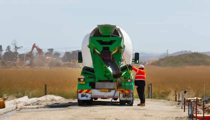 Robotnik przy betoniarce, przygotowuje się do pracy. Cena betonu zależy od wielu czynników.