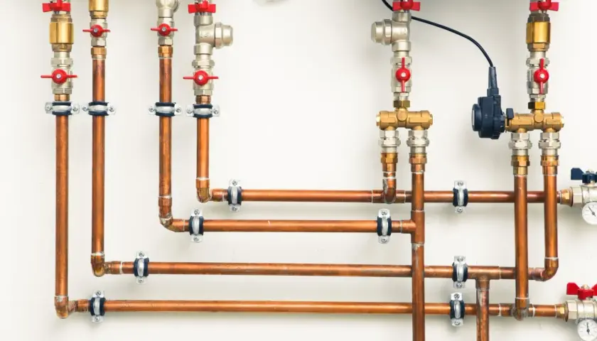 System hydrauliczny z miedzianymi rurami i zaworami. Różnica między złączkami PEX U czy TH jest kluczowa dla szczelności instalacji.